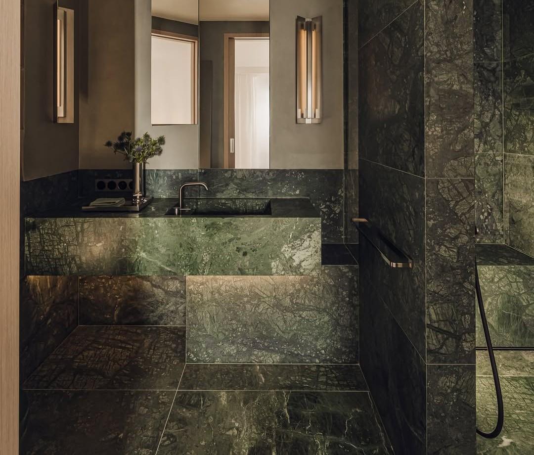 Dark marble bathroom with polished finish and luxury hotel aesthetic